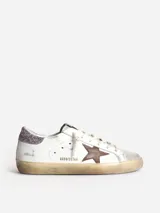 Zapatilla blanca de cuero con estrella en color cuero y refuerzo de talón con purpurina rosa.
