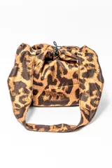 Bolso tipo bombonera con estampado animal print de leopardo en tonos marrones. Tiene cierre con cordón ajustable y asa corta para llevar al hombro.
