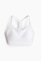 Top deportivo blanco acanalado con breteles finos y espalda nadadora. Cuenta con copas forradas con relleno extraíble y bajo elástico acanalado.