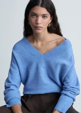 Sweater color beige de tejido de punto con cuello en V y corte oversize.