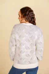 Buzo tejido color blanco con diseño en relieve de líneas verdes.