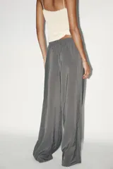 Pantalón palazzo color gris topo de tejido fluido, con cintura elástica ajustable con cordones y bolsillos laterales.