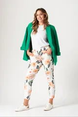 Pantalón babucha blanco con estampado de flores y hojas en tonos naranja, marrón y verde.