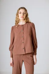 Chaqueta negra de lino con mangas abullonadas y cierre frontal con botones.