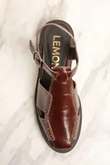 Sandalias de cuero marrón con diseño de tiras cruzadas y hebilla lateral.