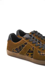 Zapatillas urbanas de cuero color crema con detalles en gris y suela de goma marrón.