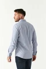 Camisa de hombre a rayas verticales azules y blancas, corte slim fit, con logo bordado en el pecho.