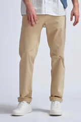 Pantalón chino color beige de corte recto con bolsillos laterales y traseros. Tobillos con dobladillo.