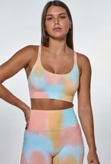 Conjunto deportivo de calza corta y top con estampado tie-dye en tonos salmón, celeste y amarillo. El top es de breteles finos y la calza es de tiro alto.