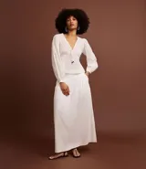 Pollera evasé midi color blanco, confeccionada en viscolino con 30% de lino, con lastex en la parte trasera de la cintura y forro interno.