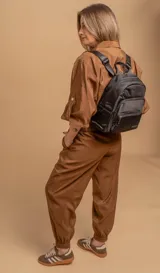 Mochila funcional color beige con detalles en negro, que incluye dos compartimentos con cierre y un bolsillo frontal para fácil acceso.