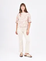 Blusa de mangas cortas con volados, color beige con estampado de líneas onduladas blancas.