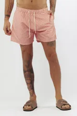 Short de baño con estampado de hojas de palmera en tonos beige, verde y naranja.