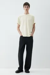 Remera de punto liviano color crema, con cuello redondo ribeteado y bajo recto. Corte estándar. Confeccionada con tejido funcional COOLMAX®, una fibra exclusiva de poliéster de secado rápido que elimina la humedad y regula la temperatura corporal.