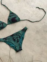 Bikini de triángulos movibles con top atable al cuello y espalda, y bottom vedetina con laterales anchos.