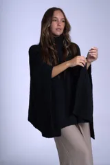 Poncho polerón negro tejido con cuello alto y mangas 3/4.