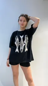 Remera blanca de algodón de corte oversize con estampado de tres peces rojos.