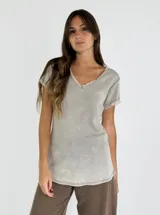 Remera color beige con cuello en V y terminaciones desflecadas.