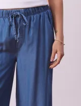 Pantalón largo de lyocell color azul, corte ancho, con pretina elastizada con lazo de ajuste, bolsillos laterales y delanteros tipo cargo.