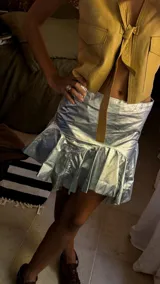 Minifalda plateada de efecto metalizado con cintura ancha y volados en el ruedo.