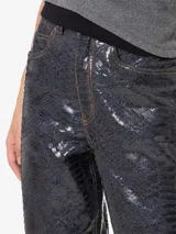Pantalón de jean de tiro alto con estampado de piel de cobra brillante, corte recto y largo hasta los tobillos.