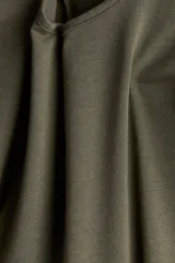 Top verde militar de punto suave, corte entallado, escote redondo amplio y mangas largas.