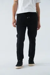 Pantalón de jogging negro de felpa con logo estampado y en goma, bolsillos con cierre, cierres en los tobillos, cintura ajustable y puños.