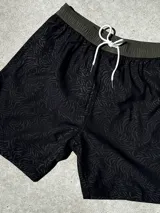 Short de baño negro con diseño de rayas en relieve, confeccionado en tela 4-Way Spandex de secado rápido.