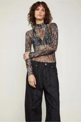 Pantalón negro con estampado de piel de serpiente, de tiro bajo y corte holgado, con puños ajustables con lazos.