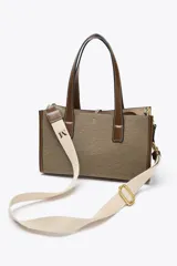 Bolso tipo shopper color marrón con doble asa corta y correa larga extraíble. Tiene detalle de pespuntes y anilla metálica decorativa. Incluye bolsa de tela interior extraíble con cierre fruncido.