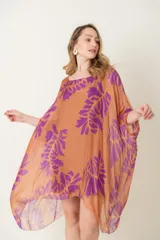 Blusa larga de seda con estampado de hojas en tonos naranja y morado, de corte suelto y mangas amplias.