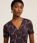 Mono largo de microfibra con estampado geométrico en tonos marrones y blancos. Tiene escote en V, mangas cortas y lazo ajustable en la cintura.