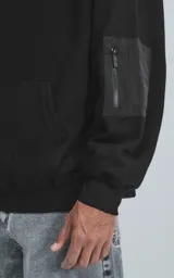 Hoodie negro oversize de rústico 100% algodón con capucha forrada y bolsillo tipo bomber con cierre en la manga.