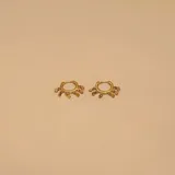 Aros tipo argolla dorados con colgantes de pequeñas monedas.
