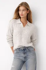 Sweater de punto trenzado color gris claro, con cuello en V y calce holgado.