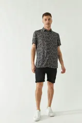 Camisa de hombre estampada, de manga corta y fit slim. Presenta cartera abotonada y logo bordado.