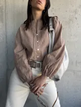 Camisa color beige con bordados florales, cuello mao y mangas largas abullonadas.