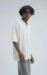 Camisa de punto abierto (crochet) color beige, manga corta y cuello polo, con calce oversize.