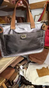 Bolso tipo tote dorado con doble asa de mano color marrón claro y correa bandolera desmontable.