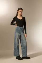 Pantalón de jean azul claro con estampado abstracto desgastado, corte baggy y tiro medio.