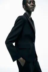 Blazer color beige de corte clásico, con cuello solapa, manga larga, bolsillos frontales con solapa y cierre frontal con un botón.