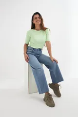 Sweater de punto color verde claro, con cuello bote y mangas cortas.