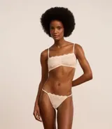 Bombacha colaless color crema con encaje floral en la parte delantera y tul en la parte trasera.