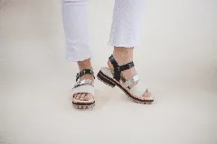 Sandalias de cuero con tiras en tonos negro y plateado, suela de goma antideslizante.