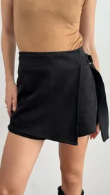 Short pollera de gamuza color negro, con cierre delantero y hebilla metálica decorativa.