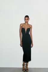 Vestido midi negro entallado, con escote corazón y hombros descubiertos. Cierre lateral con cremallera oculta en costura.
