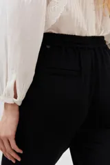 Pantalón babucha negro con cintura elastizada y cordón ajustable.