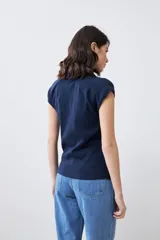 Remera azul marino de tejido canalé, con cuello polo y mangas cortas.