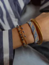 Pulsera tejida a mano con cuentas Miyuki en tonos de azul, dorado y plateado.