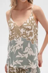 Musculosa de bretel fino con estampado floral en tonos beige, verde y blanco, corte al cuerpo y escote en V.